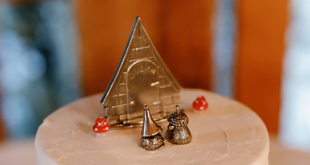 Gnome figurine cake toppers on a white wedding cake