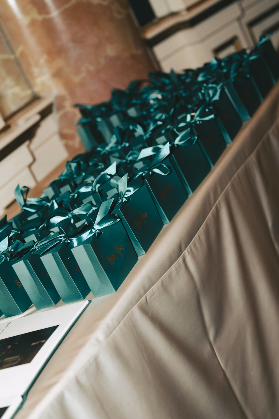 Emerald green ribbon place cards arranged in a row along a reception table
