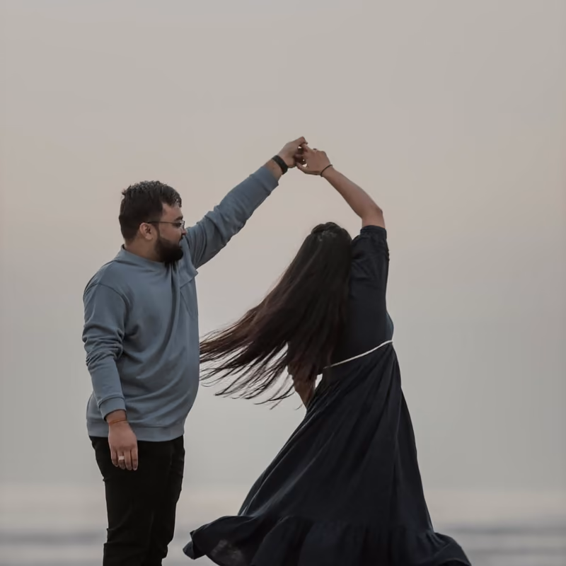 A couple sharing their first dance outdoors on a paved area near the water